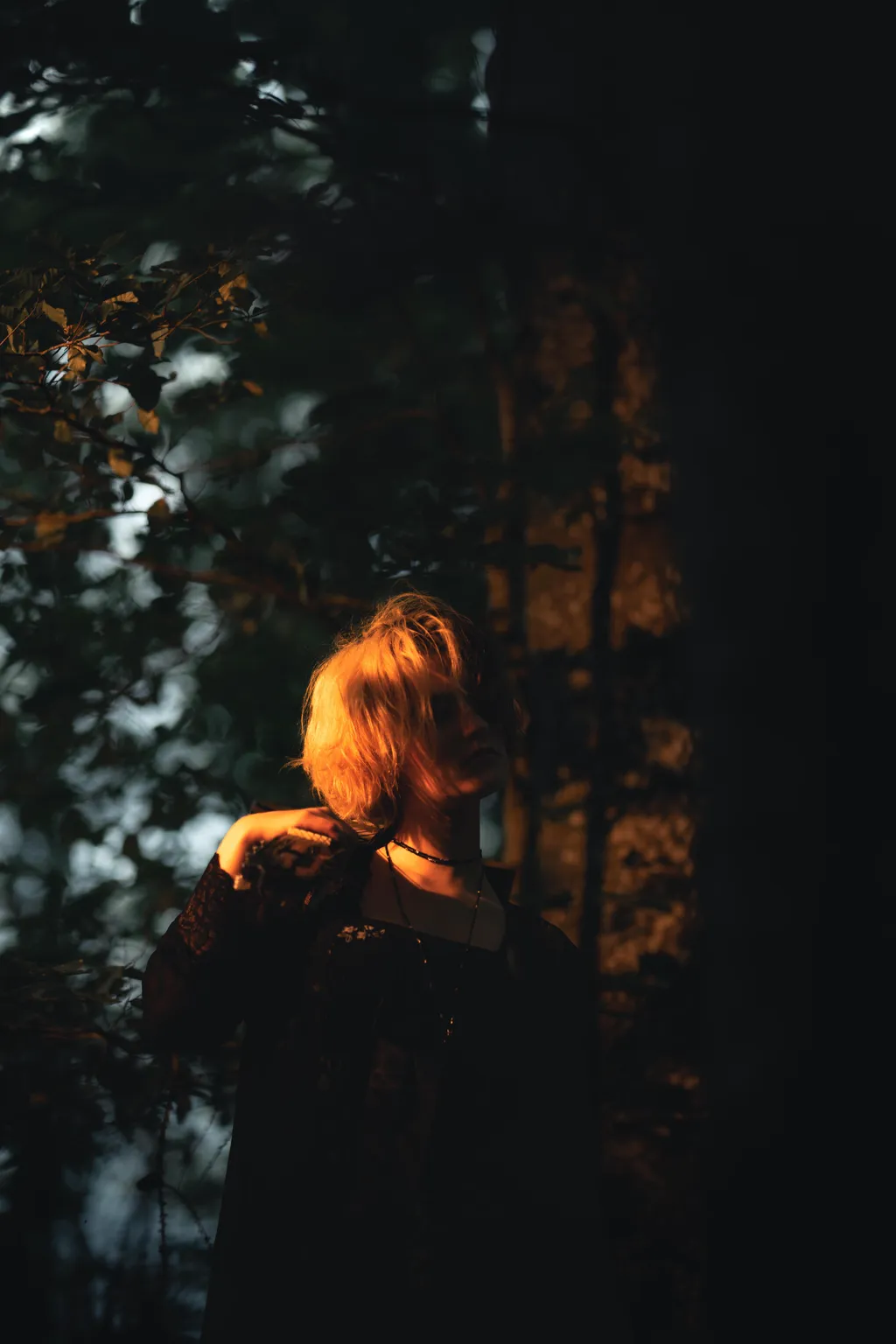 Woman in black with windswept hair against autumnal forest tones in a Luxembourg portrait