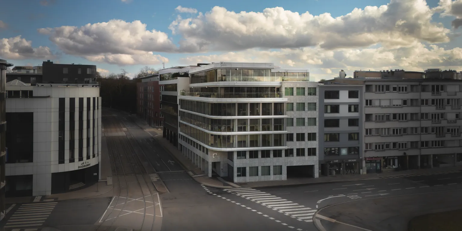 Elevated wide shot of DLA Piper's office building and surrounding Luxembourg streets under cloudy skies