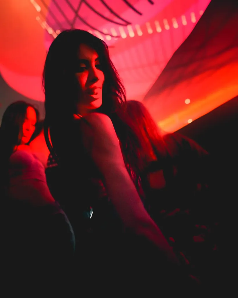 Two women on the dance floor bathed in deep red club lighting during a Luxembourg nightlife video shoot