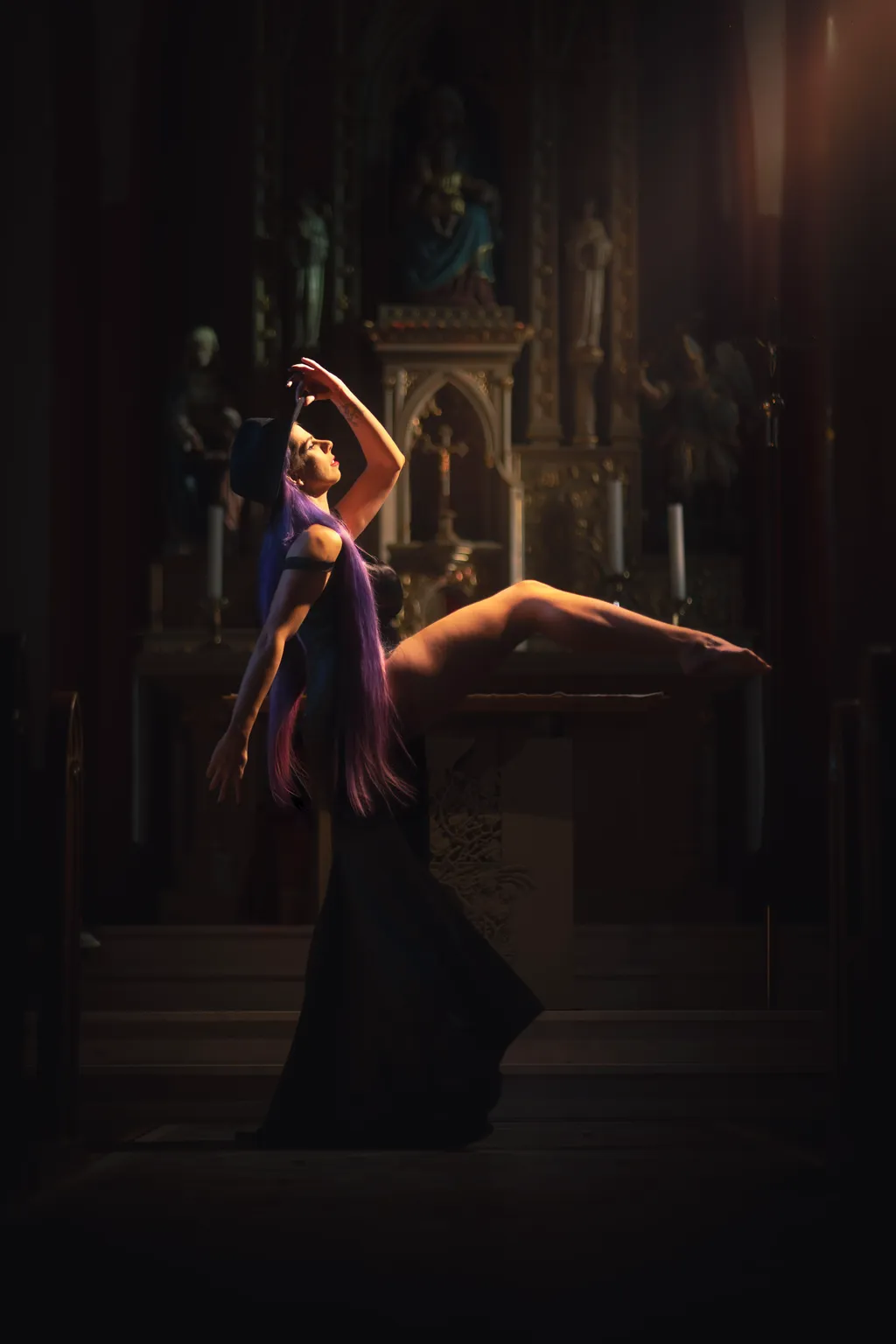 Editorial portrait of a woman with long hair arching gracefully in warm altar light, fine-art photography Luxembourg